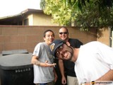 Three Men Strike a Pose in Front of a Trash Can