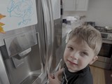 Young Boy Opening Stainless Steel Refrigerator Door