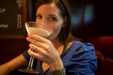 Woman Sipping Creamy Cocktail at Upscale Bar
