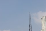 Towering Skyscraper with Radio Tower and Construction Crane