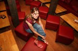 Woman Adjusting Heels in Stylish Red Lounge