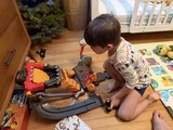Young Boy Playing with Monster Truck Toy Set at Home