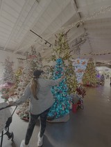 Woman Decorating Blue Christmas Tree Display