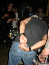 Tattooed Man Holds Up Jeans