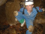 Female Caver Navigating Tight Underground Passage