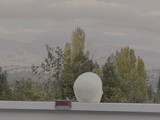 White Sculptural Head Against Mountain Landscape