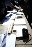Man Examining Documents and Leather Bag on Table