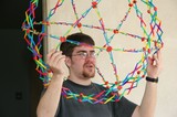 Young Man Holds Colorful K'NEX Geometric Sphere Construction