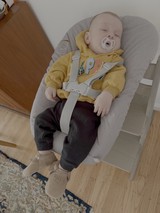 Baby Peacefully Sleeping in Bouncer Chair
