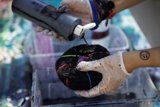 Gloved Hand Holding Black Ball