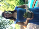 Woman in Blue Dress Holds Floral Arrangement Poolside