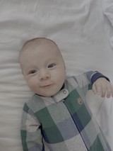 Sweet Baby in Striped Outfit on White Bedding