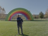 Man Posing with Large Rainbow Art Installation