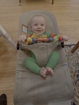 Happy Baby Playing in Bouncy Seat