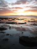 Fiery Sunset Reflections on Rocky Shores