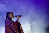 FKA twigs Beautiful Upper Body Profile Singing Eyes Closed Baby Hairs Swirls Hoop Earrings Red Lipstick Braided Ponytail Rings Kimono Red Brocade Gold Patterns Purple Blue Lighting Heavy White Haze