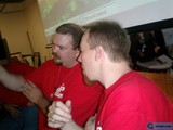 Two Men In Red Shirts Using Computers