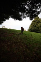 Child Playing on Hillside at Dusk Under Trees