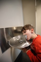 Young Boy Drinking from Water Fountain at Museum