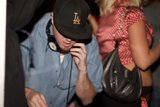Blue Shirt, Baseball Cap, and Finger In The Air