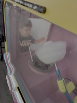 Child Operating Cotton Candy Machine at Fair