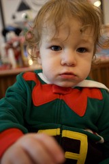 Toddler in Green Elf Costume with Serious Expression