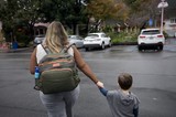 Mother and Child Crossing Parking Lot at Dusk