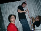 Three Men in Front of Curtain