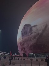 Futuristic Sphere Building with Digital Display at Night