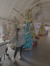 Woman Decorating Turquoise Christmas Tree in Holiday Display