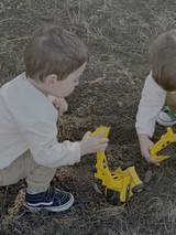 Children Playing with Yellow Toy Trucks Outdoors