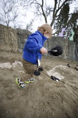 Young Child Engaged in Archaeological Play with Brushes