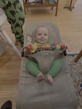 Happy Baby in Bouncer with Colorful Toy