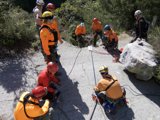 Orange-clad Rescuers Scaling Rocky Terrain