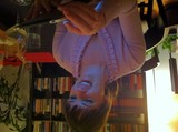 Woman Smiling at Phone Glow in Cozy Library
