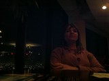 Contemplative Woman at Dimly Lit Urban Restaurant