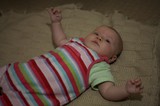 Curious Infant Gazing Upward on Knit Blanket