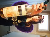 Woman enjoying a bottle of wine by the window