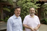 Two Men Enjoying the Outdoors in Front of a House