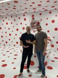 Two Men Standing in Front of a Bold Polka Dot Wall