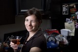 Woman Winking with Cocktail in Home Kitchen