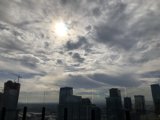 Sunlight breaks through cloudy cityscape