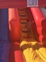 Child Climbing Through Inflatable Bounce House Obstacle