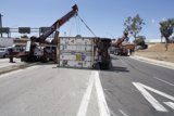 Crane lifts overturned truck off the road