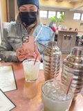 Masked Woman Enjoying a Drink Indoors