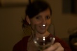 Woman Raising a Wine Glass in Dim Light