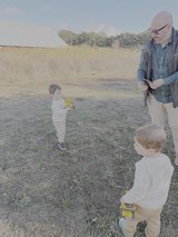 Grandfather Playing with Children in Rural Field
