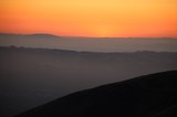 Layered Mountain Silhouettes at Fiery Sunset Dusk