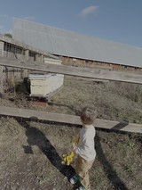 Young Child Exploring Farm with Yellow Toy