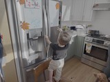 Toddler Exploring Kitchen Refrigerator at Home